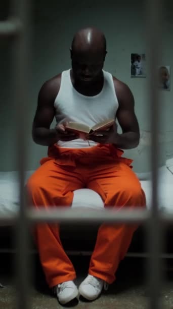 Vertikální Výstřel Skrz Zamřížovanou Stěnu Černého Vězně Jak Sedí Posteli — Stock video