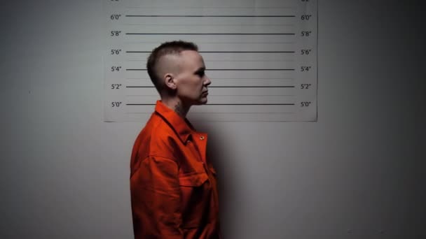 Ύποπτη Γυναίκα Πορτοκαλί Στολή Φυλακής Μπαίνει Στο Δωμάτιο Κρατώντας Πινακίδα — Αρχείο Βίντεο