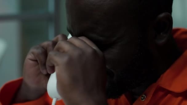 Närbild Förtvivlad Afroamerikansk Fånge Fängelseuniform Pratar Telefon Och Gråter Besöksrummet — Stockvideo