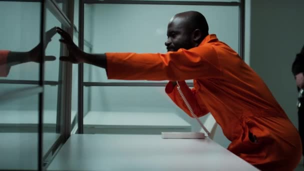 Вид Сбоку Эмоционального Чернокожего Заключенного Сидящего Комнате Посещений Говорящего Любимым — стоковое видео