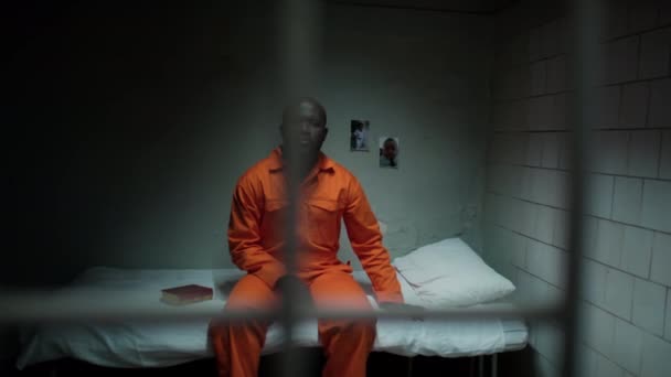 Udsigt Gennem Barer Ulykkelig Afrikansk Amerikansk Fange Orange Uniform Sidder – Stock-video