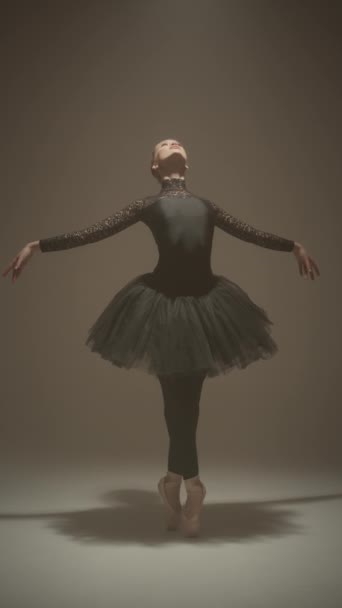 ポントで踊る黒いチュートリアのエレガントなバレリーナの垂直ショットは サイクルウォールでスタジオで古典的なバレエパフォーマンスを与えながら — ストック動画