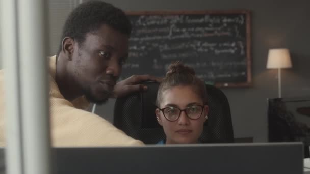 年轻的黑人程序员在办公室工作时指着电脑屏幕向女性It项目经理解释代码 — 图库视频影像