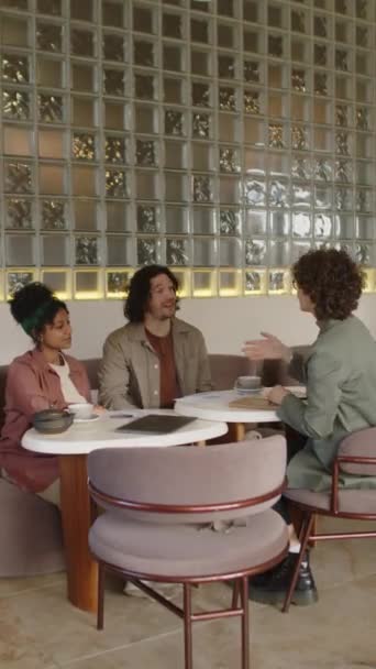 在咖啡店咨询过程中 年轻夫妇与女商务顾问交谈握手的垂直镜头 — 图库视频影像