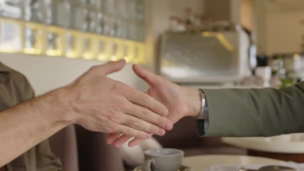 在咖啡店见面时 业务伙伴达成交易的亲密握手镜头 — 图库视频影像