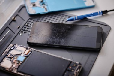 Elektronik tamir atölyesinde kırık dokunmatik ekranlı akıllı telefonun kapatılması