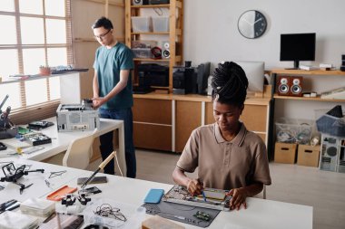 Elektronik cihazın siyah teknisyen lehimleme elementi, arka plan üzerinde çalışan erkek arkadaşı.