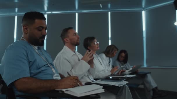 Professzionális Orvosok Ülnek Konferenciateremben Hallgatják Felszólalókat Jegyzetelnek Orvosi Szeminárium Alatt — Stock videók