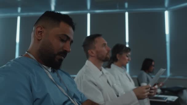 Tıp Üniformalı Bir Ortadoğu Doktorunun Bir Grup Meslektaşıyla Oturup Sağlık — Stok video