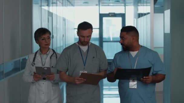 Gruppo Tre Medici Professionisti Che Camminano Insieme Attraverso Corridoio Discutono — Video Stock