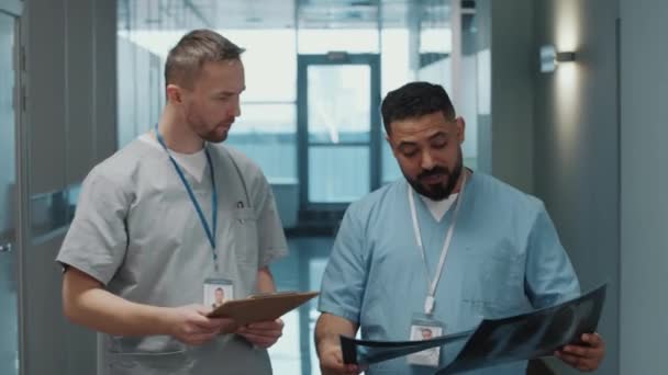 Два Врача Мужчины Медицинской Форме Обсуждают Рентгеновское Сканирование Время Прогулки — стоковое видео