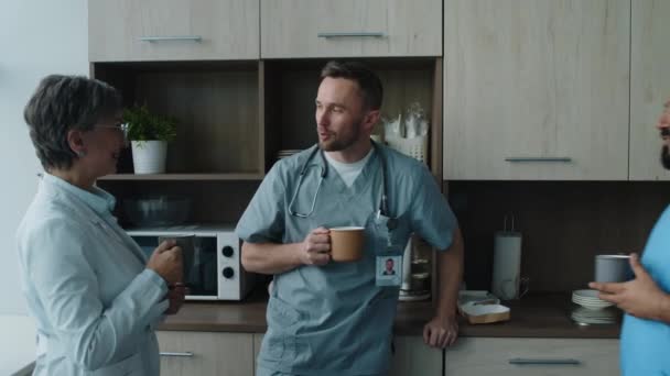 Bedrijf Van Ziekenhuismedewerkers Die Discussiëren Drinken Uit Mokken Tijdens Het — Stockvideo