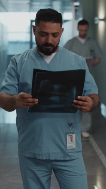 제복에 의사의 초상화 엑스레이 이미지를 검사하고 복도에 사진기에 — 비디오