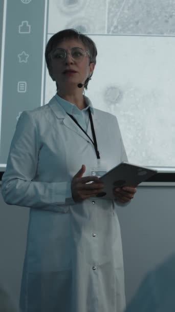 Imagem Vertical Uma Microbiologista Vestindo Casaco Branco Microfone Segurando Tablet — Vídeo de Stock