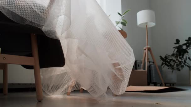 Nahaufnahme Eines Mit Luftpolsterfolie Bedeckten Sessels Wohnzimmer Ohne Menschen Umzug — Stockvideo