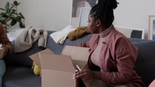 Mujer Afroamericana Empacando Juguetes Una Caja Cartón Con Ayuda Hijo — Vídeo de stock