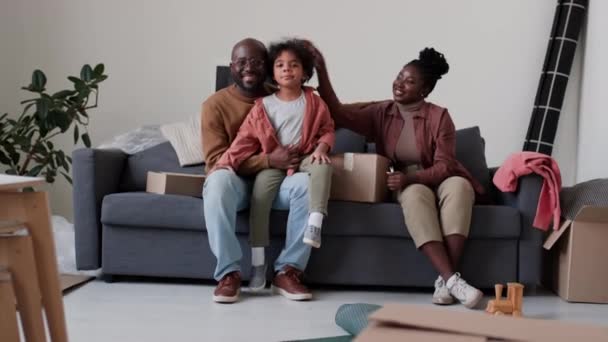 소파에 새로운 집에서 상자와 거실에서 카메라에 아프리카계 가족의 초상화 — 비디오