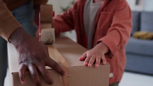 Little African American Chłopiec Uszczelnienie Kartonowe Pudełko Pomagając Ojcu Pakowaniu — Wideo stockowe