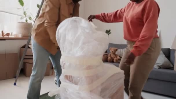 搬进新房子后 非洲裔美国人的妻子和丈夫在客厅里打开椅子 — 图库视频影像
