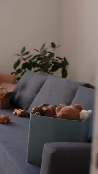 搬进新房子后 在客厅沙发上的盒子里垂直地穿过玩具的门 — 图库视频影像