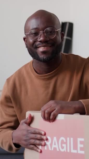 Verticaal Portret Van Vrolijke Afro Amerikaanse Man Met Kartonnen Doos — Stockvideo