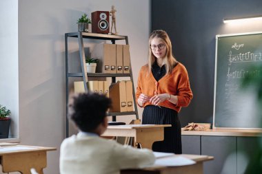 Çocuklarla çalışan modern beyaz kadın müzik öğretmeninin seçici odak noktası, boşluğu kopyalamak