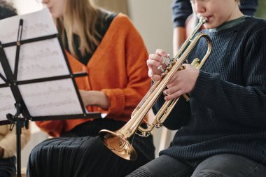 Okul orkestrasında trompet çalan oğlanın seçmeli odak noktası.