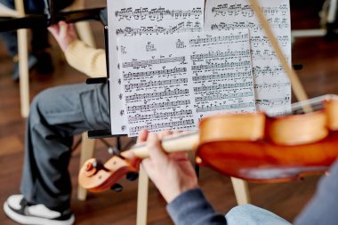 Okul orkestrasında müzik enstrümanları çalan tanınmayan öğrencilerin nota çekimlerine odaklan