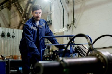 Kafkasyalı genç teknisyenlerin fabrika atölyesinde çalıştığı orta boy bir fotoğraf.