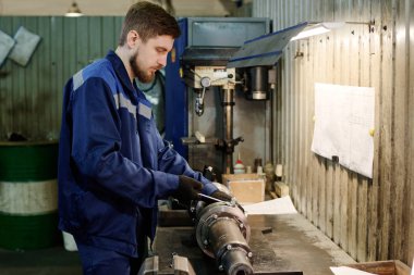 Delikanlının fabrika atölyesinde metal işi yaparken orta ölçekli görüntüsü, boşluğu kopyala