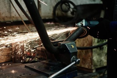 Metal işçiliği yaparken açı öğütücü kullanan tanınmayan bir adamın yakın plan görüntüsü, boşluk kopyala