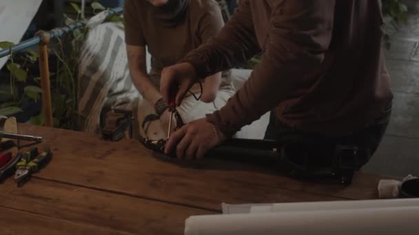 Наклонив Снимок Выжившего Мужчины Помощью Отвертки Починить Бионическую Руку Девушки — стоковое видео
