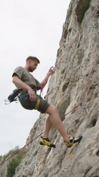 Verticaal Schot Van Mannelijke Bergbeklimmer Abseilen Van Rots Ontbinden Touw — Stockvideo