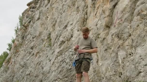 Genç Adam Kayanın Dibinde Duruyor Tırmanmadan Önce Koşum Takımına Hızlı — Stok video