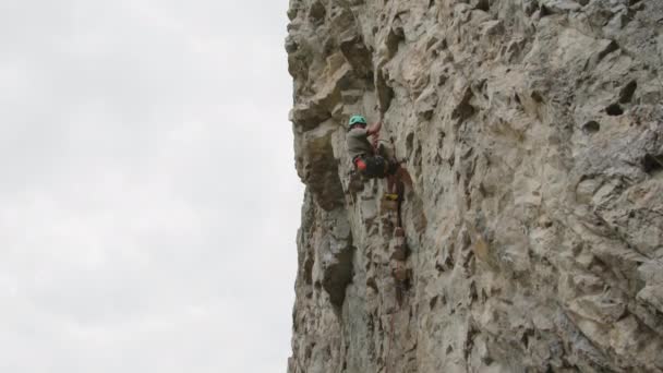 专业登山者头戴安全帽 用绳索系住岩石的宽片 — 图库视频影像