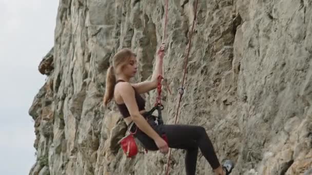 Молодая Альпинистка Спортивной Одежде Верёвкой Спускается Скале — стоковое видео