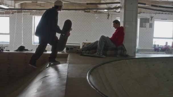 Jeune Homme Chevauchant Skateboard Son Ami Assis Skatepark Garçons Saluant — Video
