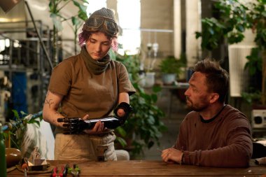 Kafkasyalı mühendis engelli genç kadını izliyor protez kol deniyor, enkaz estetiği deniyor