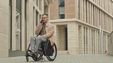 Tekerlekli sandalyedeki genç adamın şehir merkezindeki bir sokakta cep telefonuyla konuşurken şehirde dışarıda geçirdiği günlerin fotokopi çekimleri.