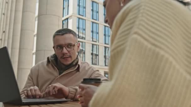 Mladý Muž Pomocí Notebooku Diskutovat Práci Kolegyní Kávu Zatímco Sedí — Stock video
