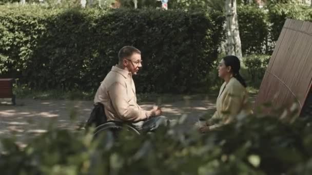 Θέα Πάνω Από Πράσινο Θάμνους Του Ανθρώπου Αναπηρική Καρέκλα Πίνοντας — Αρχείο Βίντεο