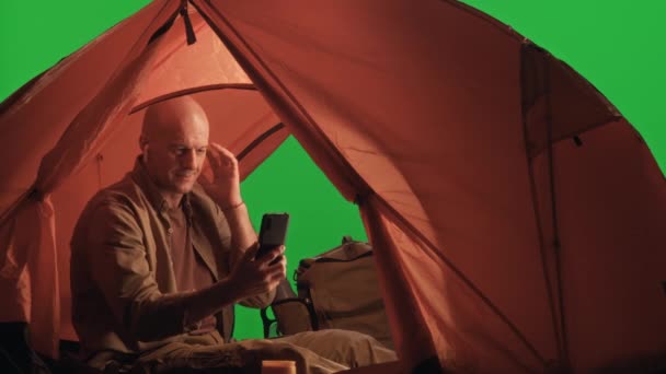 Kablosuz Kulaklıklı Erkek Turist Yeşil Krom Anahtar Arka Planında Kamp — Stok video