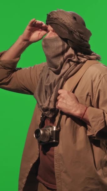 Pionowe Ujęcie Męskiego Podróżnika Beduińskim Chustce Stojącego Naprzeciw Ściany Zielonego — Wideo stockowe