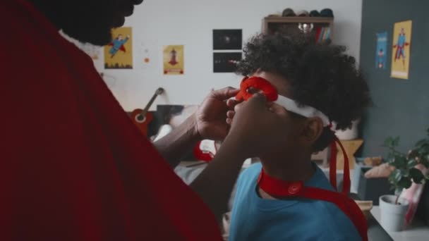 Preto Pai Colocando Máscara Super Herói Pequeno Filho Seguida Correr — Vídeo de Stock