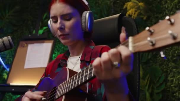 Młoda Artystka Muzyki Żeńskiej Słuchawkach Gra Gitarze Nagrywa Piosenkę Nowoczesnym — Wideo stockowe