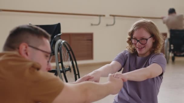 Молодая Девушка Инвалидностью Улыбается Держится Руки Партнером Делает Сидя Вперед — стоковое видео