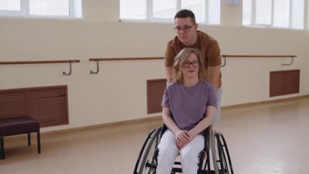 Mladý Dobrovolník Tlačí Dívku Invalidním Vozíku Přes Taneční Studio Pak — Stock video