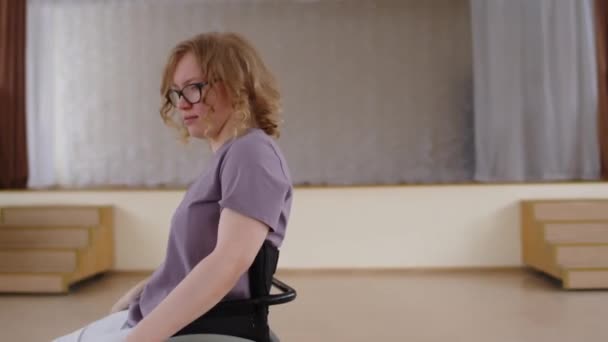 Young Positive Girl Riding Wheelchair Recital Hall Turning Camera Posing — Stock Video