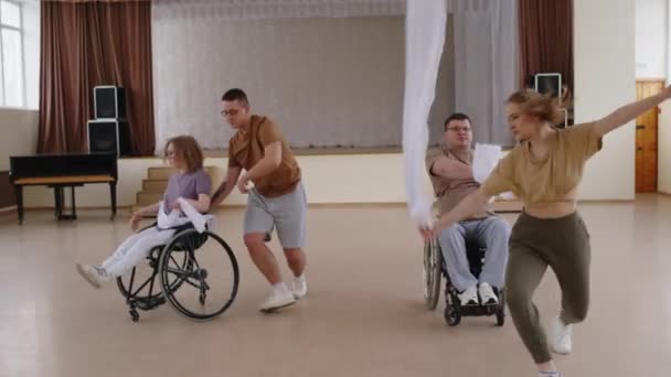 휠체어에 남성과 댄서와 그들의 파트너는 리사이틀 홀에서 리허설에 리본과 — 비디오