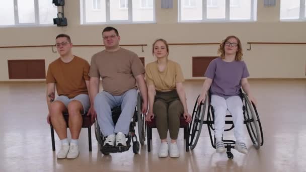男男女女坐在轮椅上排着队 一边练习舞步 一边在演播室排练 — 图库视频影像